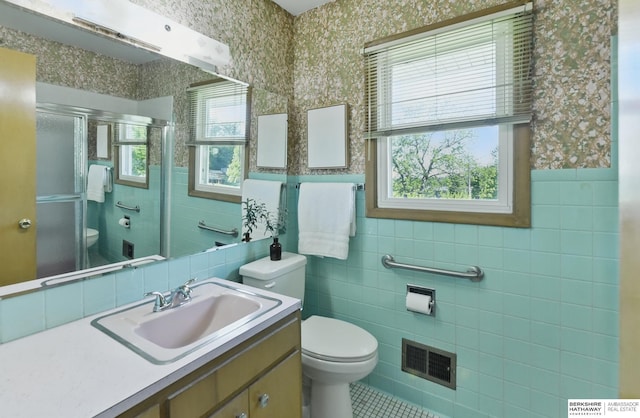 4314 Oak St, Omaha, NE 68105 - bathroom with tile walls, toilet, a shower stall, vanity, and tile patterned floors