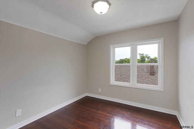 3013 Decatur St, Omaha, NE 68111 - empty room featuring baseboards, dark wood-style flooring, and vaulted ceiling