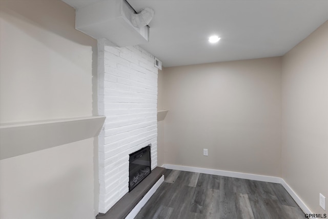 3013 Decatur St, Omaha, NE 68111 - unfurnished living room featuring dark wood-type flooring, a brick fireplace, baseboards, and recessed lighting