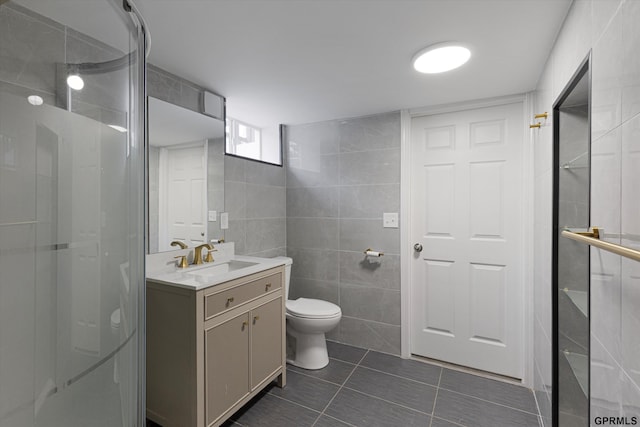 3013 Decatur St, Omaha, NE 68111 - bathroom featuring tile walls, toilet, tile patterned flooring, a shower stall, and vanity