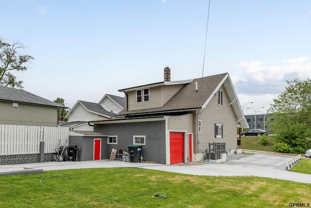 3013 Decatur St, Omaha, NE 68111 - back of house featuring a patio, a chimney, a shingled roof, central air condition unit, and a garage