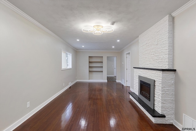 3013 Decatur St, Omaha, NE 68111 - unfurnished living room featuring hardwood / wood-style floors, built in shelves, baseboards, ornamental molding, and a stone fireplace