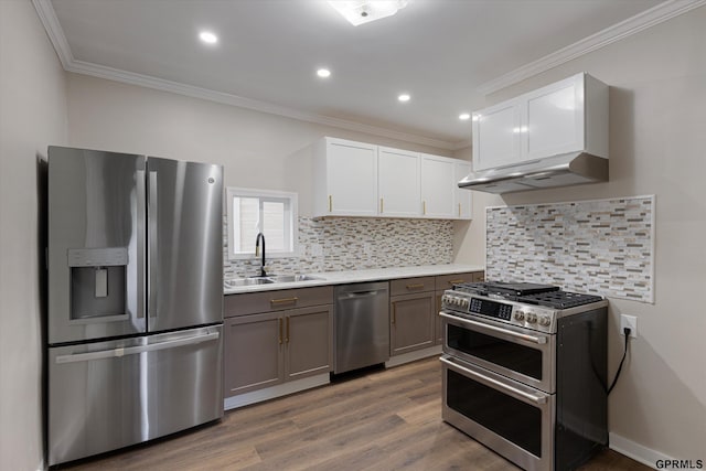 3013 Decatur St, Omaha, NE 68111 - kitchen featuring appliances with stainless steel finishes, a sink, crown molding, light countertops, and wood finished floors