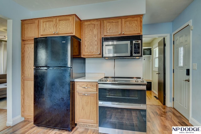 4705 N 95th St, Omaha, NE 68134 - kitchen with stainless steel appliances, light wood-style floors, light countertops, and baseboards