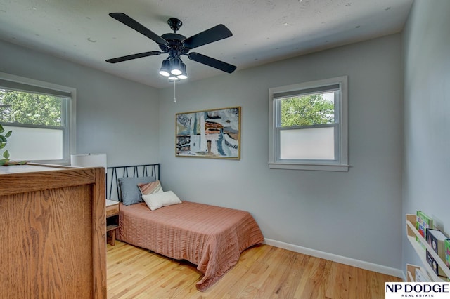 4705 N 95th St, Omaha, NE 68134 - bedroom featuring multiple windows, baseboards, wood finished floors, and a ceiling fan