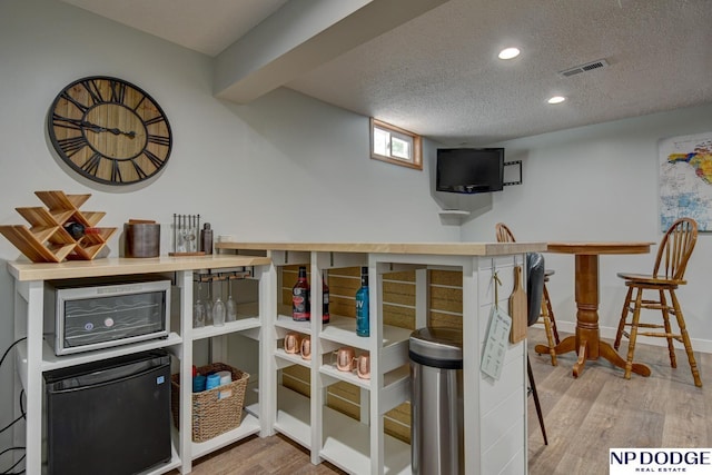 4705 N 95th St, Omaha, NE 68134 - indoor bar with wood finished floors, a textured ceiling, recessed lighting, and baseboards