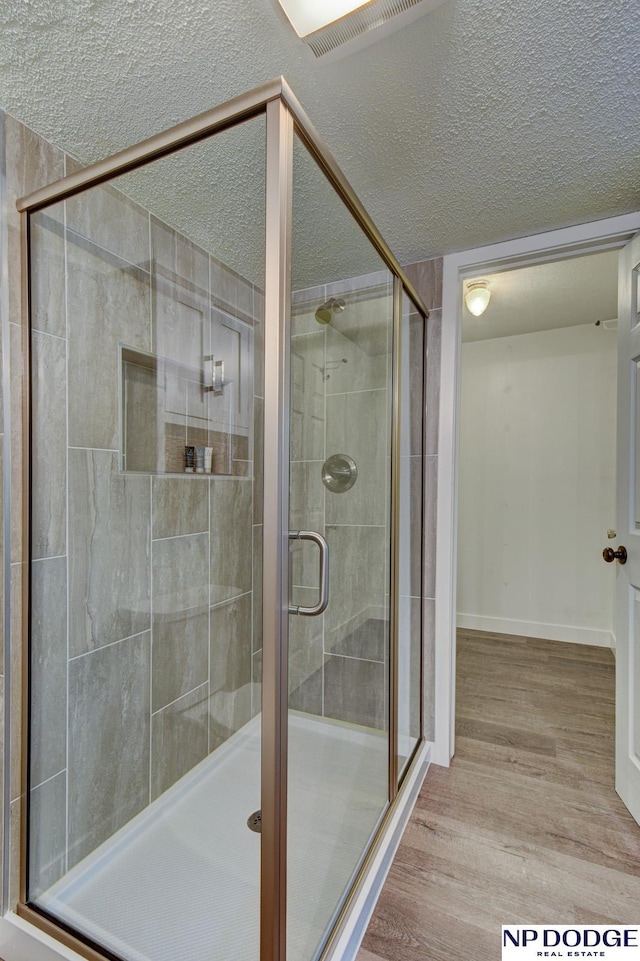 4705 N 95th St, Omaha, NE 68134 - full bath featuring a shower stall, wood finished floors, a textured ceiling, and baseboards