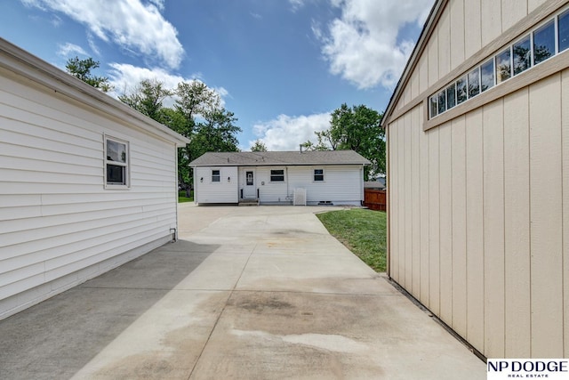 4705 N 95th St, Omaha, NE 68134 - rear view of house with a patio area, board and batten siding, and concrete driveway
