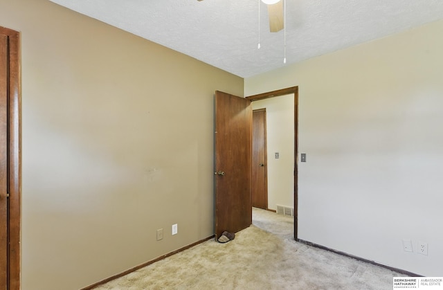 128 S 110th St, Omaha, NE 68154 - empty room featuring light colored carpet, baseboards, ceiling fan, and a textured ceiling