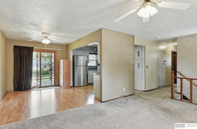 128 S 110th St, Omaha, NE 68154 - unfurnished room featuring ceiling fan, a textured ceiling, light colored carpet, baseboards, and light wood-style floors