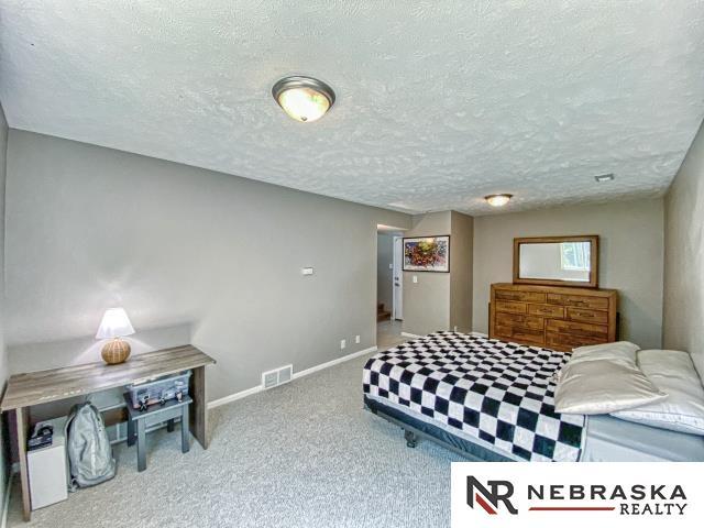 14603 Nebraska Cir, Omaha, NE 68116 - bedroom featuring carpet flooring, a textured ceiling, and baseboards