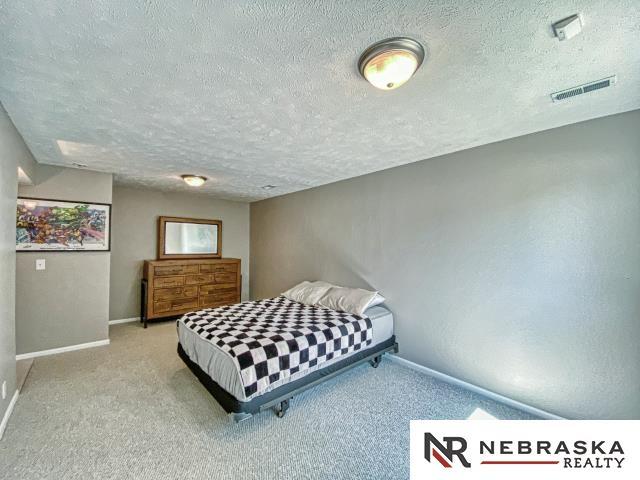 14603 Nebraska Cir, Omaha, NE 68116 - carpeted bedroom featuring a textured ceiling and baseboards