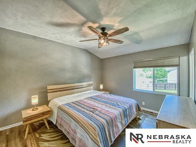 14603 Nebraska Cir, Omaha, NE 68116 - bedroom with baseboards, wood finished floors, a textured ceiling, ceiling fan, and lofted ceiling