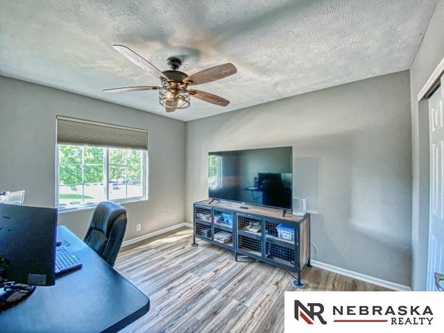 14603 Nebraska Cir, Omaha, NE 68116 - office area with wood finished floors, a textured ceiling, ceiling fan, and baseboards