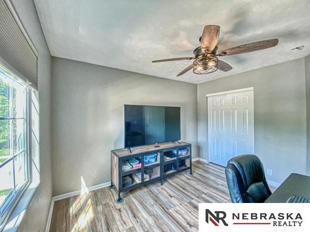 14603 Nebraska Cir, Omaha, NE 68116 - home office featuring baseboards, ceiling fan, wood finished floors, and a textured ceiling