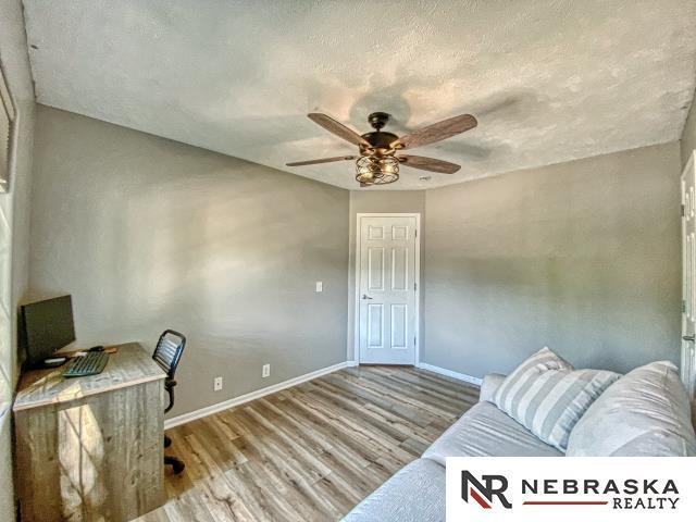 14603 Nebraska Cir, Omaha, NE 68116 - office area with wood finished floors, a ceiling fan, and baseboards