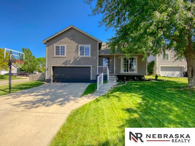 14603 Nebraska Cir, Omaha, NE 68116 - tri-level home with an attached garage, a front lawn, and driveway