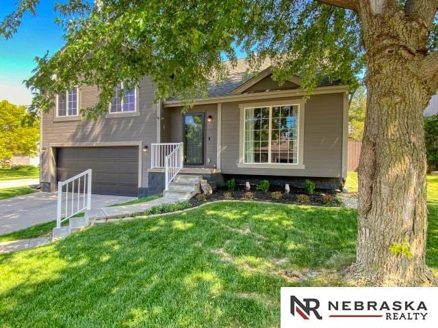 14603 Nebraska Cir, Omaha, NE 68116 - split level home with a front lawn, an attached garage, and concrete driveway