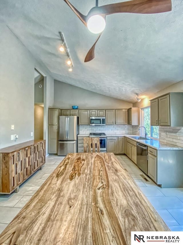 14603 Nebraska Cir, Omaha, NE 68116 - kitchen featuring appliances with stainless steel finishes, vaulted ceiling, backsplash, gray cabinets, and light countertops