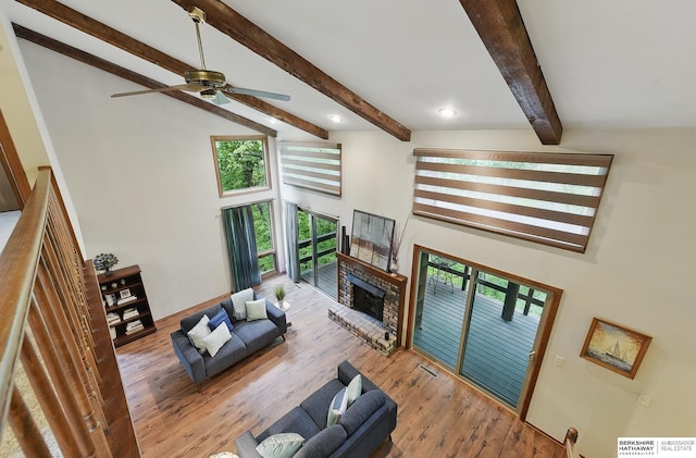 301 Oakridge Ct, Bellevue, NE 68005 - living area with healthy amount of natural light, a ceiling fan, a towering ceiling, a fireplace, and beam ceiling
