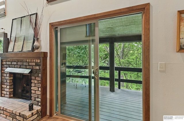 301 Oakridge Ct, Bellevue, NE 68005 - doorway to outside with a brick fireplace and wood finished floors