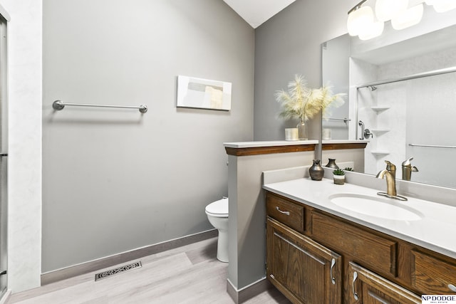 13952 Frederick Cir, Omaha, NE 68138 - full bathroom featuring wood finished floors, vanity, a shower stall, and toilet