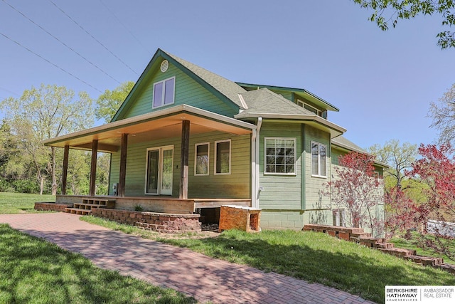 5531 County Road 34, Fort Calhoun, NE 68023 - view of front of property with a porch, a front lawn, and a shingled roof