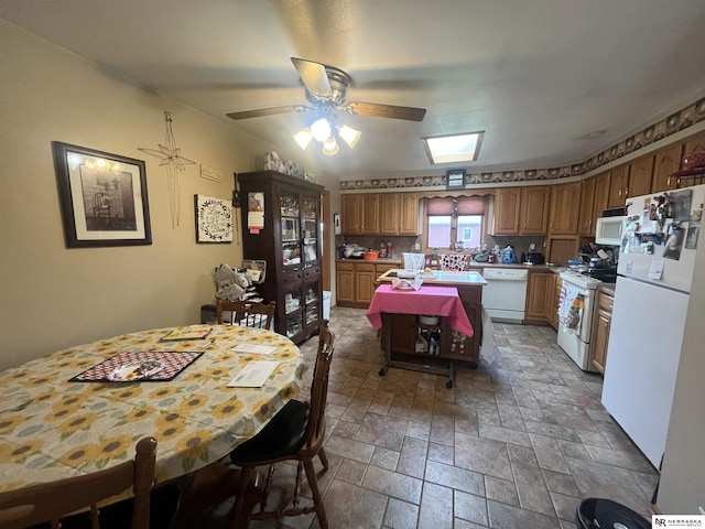901 E 9th St, Valentine, NE 69201 - kitchen with white appliances, stone tile flooring, a ceiling fan, light countertops, and a center island