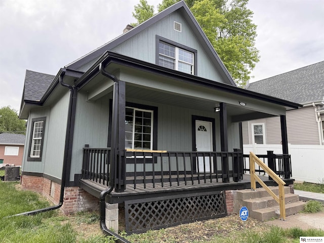 914 S 26th St, Omaha, NE 68105 - view of front facade with a porch, a chimney, central air condition unit, and roof with shingles