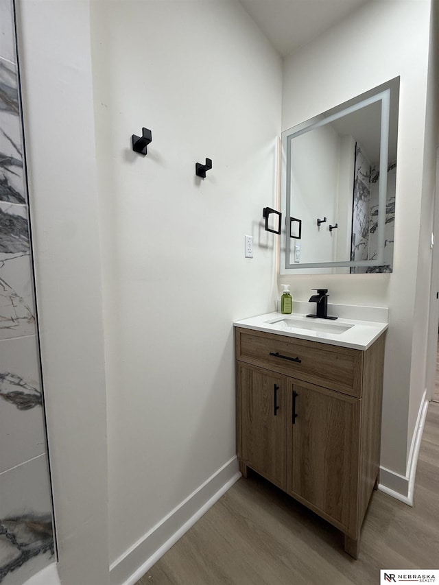 914 S 26th St, Omaha, NE 68105 - bathroom featuring wood finished floors, vanity, and baseboards