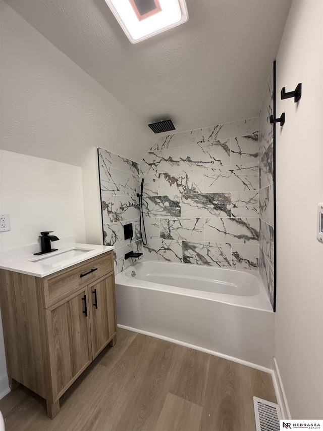 914 S 26th St, Omaha, NE 68105 - bathroom featuring wood finished floors, a combined bath / shower with rainfall shower, vanity, and vaulted ceiling