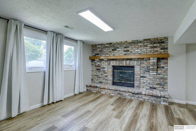 14014 S 35th St, Bellevue, NE 68123 - unfurnished living room featuring a textured ceiling, wood finished floors, a fireplace, and baseboards