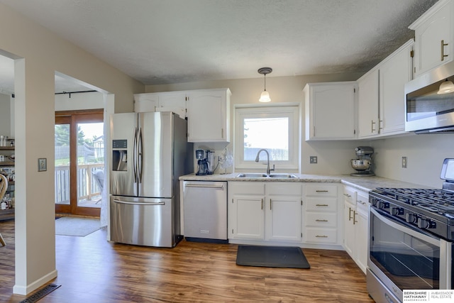 14014 S 35th St, Bellevue, NE 68123 - kitchen with appliances with stainless steel finishes, a sink, dark wood-style flooring, white cabinetry, and pendant lighting