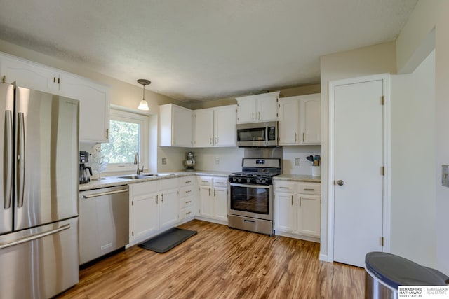 14014 S 35th St, Bellevue, NE 68123 - kitchen with appliances with stainless steel finishes, a sink, light wood-style floors, white cabinetry, and light countertops