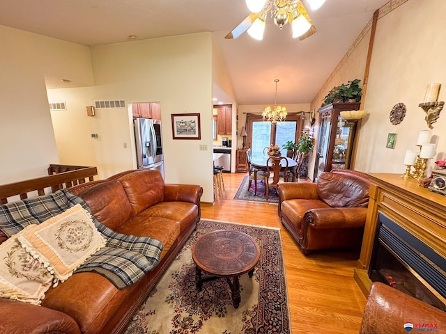 1507 SW 13th St, Lincoln, NE 68522 - living area with light wood finished floors, a ceiling fan, lofted ceiling, a chandelier, and a fireplace