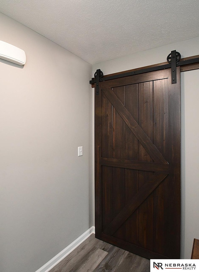 4062 W Gary Gately St, Lincoln, NE 68528 - detailed view of a barn door, wood finished floors, a wall unit AC, and baseboards