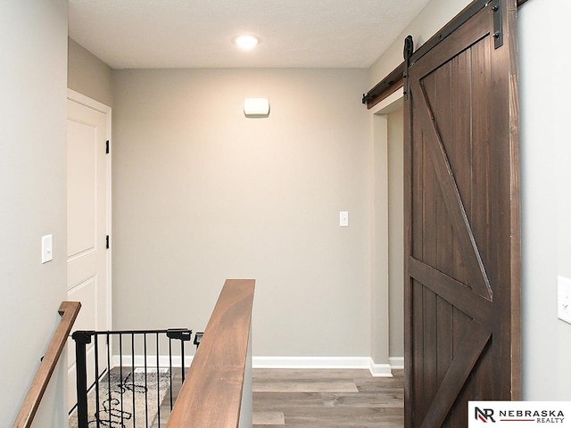 4062 W Gary Gately St, Lincoln, NE 68528 - hall with a barn door, wood finished floors, baseboards, and recessed lighting