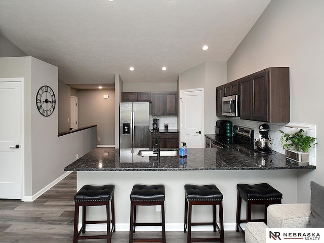 4062 W Gary Gately St, Lincoln, NE 68528 - kitchen with stainless steel appliances, a sink, tasteful backsplash, dark brown cabinets, and a peninsula