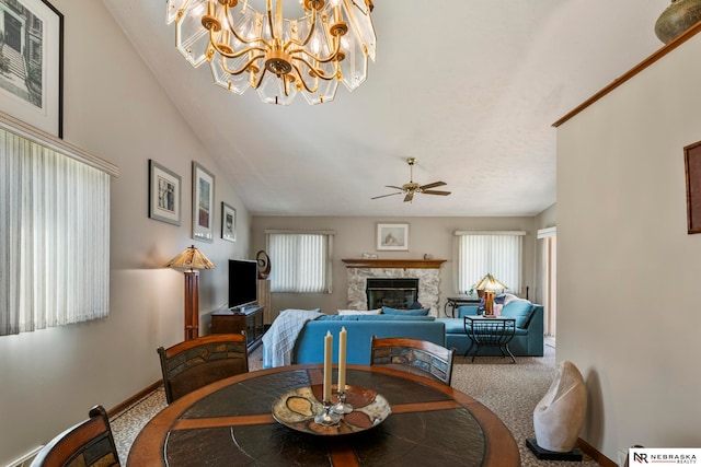 5082 S 149th Ct, Omaha, NE 68137 - carpeted dining room featuring a fireplace, ceiling fan, baseboards, a chandelier, and lofted ceiling