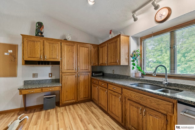 5082 S 149th Ct, Omaha, NE 68137 - kitchen featuring a sink, brown cabinets, light wood-style floors, vaulted ceiling, and dishwasher