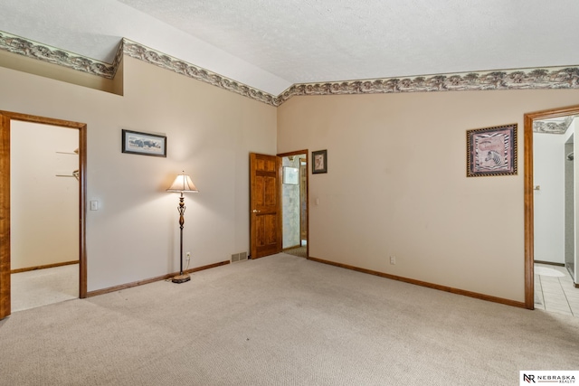 5082 S 149th Ct, Omaha, NE 68137 - empty room featuring light colored carpet, lofted ceiling, baseboards, and a textured ceiling