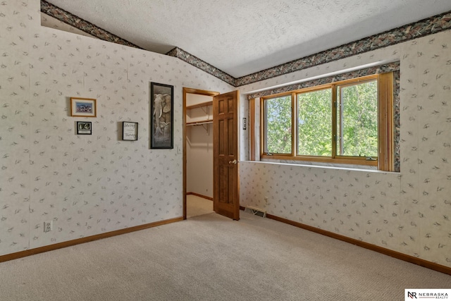 5082 S 149th Ct, Omaha, NE 68137 - unfurnished bedroom with wallpapered walls, a textured ceiling, carpet floors, and a closet