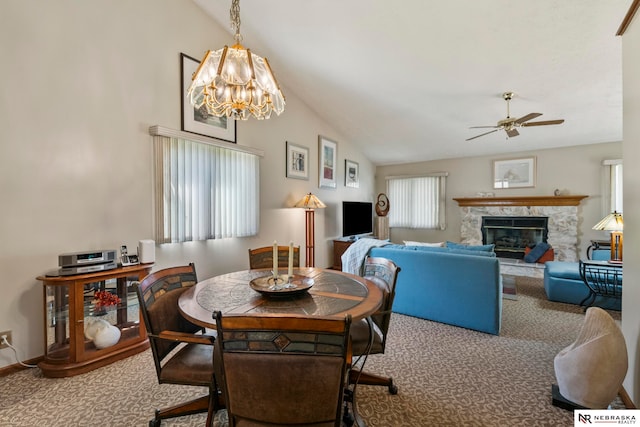 5082 S 149th Ct, Omaha, NE 68137 - dining area with carpet floors, a ceiling fan, a chandelier, a glass covered fireplace, and vaulted ceiling