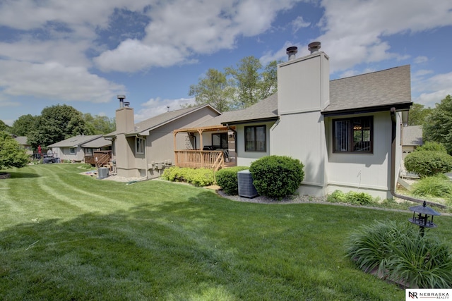 5082 S 149th Ct, Omaha, NE 68137 - back of property featuring a chimney, a yard, a shingled roof, a wooden deck, and central AC unit