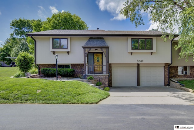 5082 S 149th Ct, Omaha, NE 68137 - bi-level home featuring a garage, concrete driveway, a front yard, and brick siding