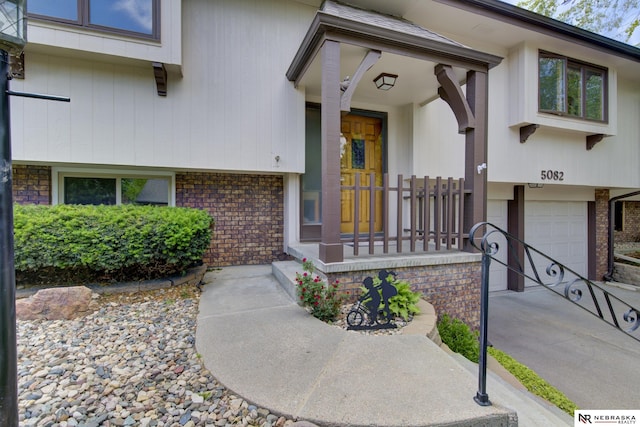 5082 S 149th Ct, Omaha, NE 68137 - entrance to property with brick siding, an attached garage, and concrete driveway