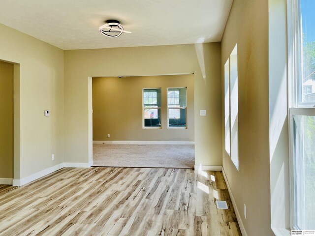 6916 N 24th St, Omaha, NE 68112 - unfurnished room featuring light wood-type flooring, healthy amount of natural light, and baseboards