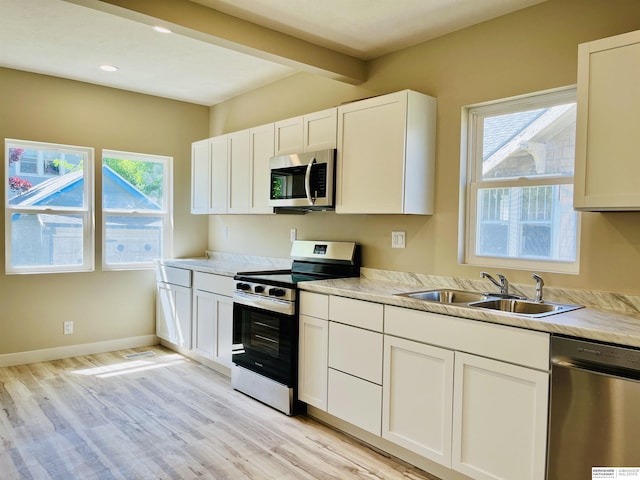 6916 N 24th St, Omaha, NE 68112 - kitchen with appliances with stainless steel finishes, a sink, light wood-style flooring, plenty of natural light, and recessed lighting
