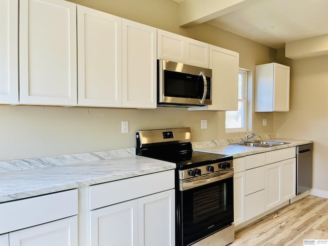 6916 N 24th St, Omaha, NE 68112 - kitchen with appliances with stainless steel finishes, a sink, light wood-style floors, white cabinetry, and light countertops