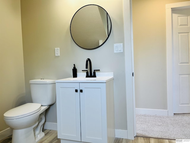 6916 N 24th St, Omaha, NE 68112 - bathroom featuring toilet, vanity, baseboards, and wood finished floors